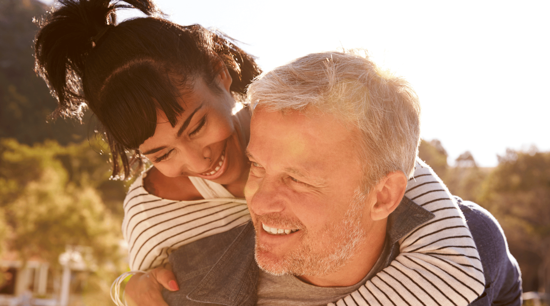 Forties or fifties couple with woman jumping on man's shoulders